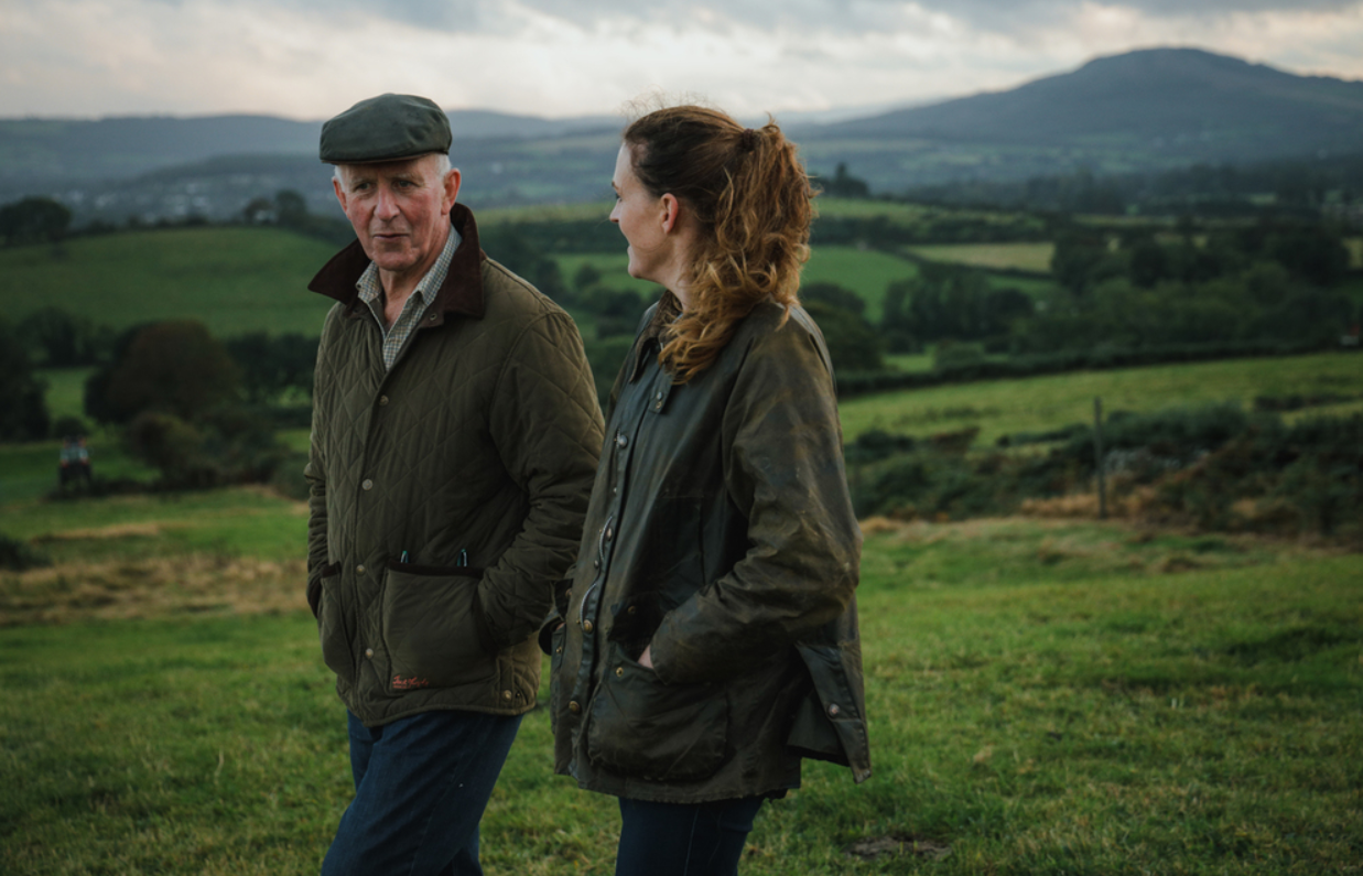 dos granjeros caminando por un paisaje irlandés